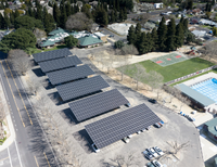 Aerial view of the Three Oaks Community Center and Walter Graham Aquatic Center parking lot with multiple rows of solar panel canopies.